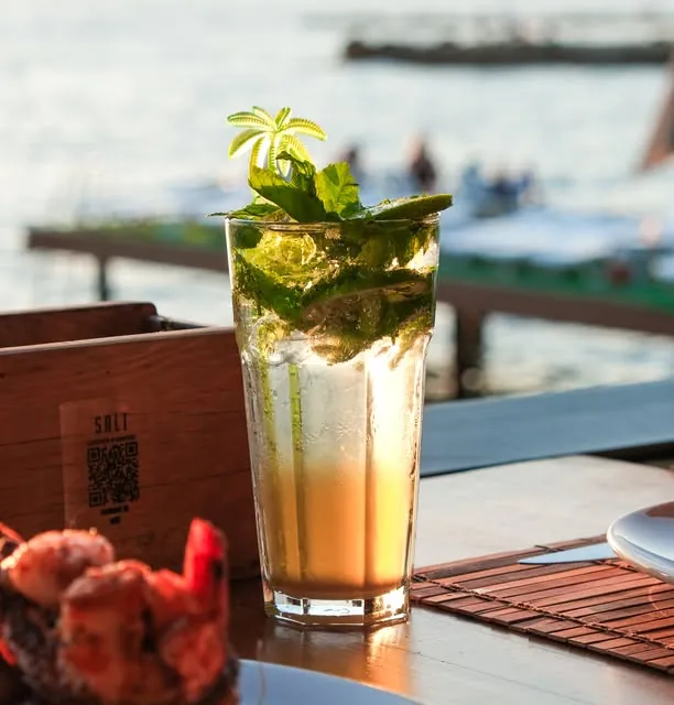 Cocktail at the water's edge with boats behind