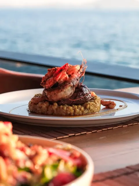 King prawn over steak with the sea beyond