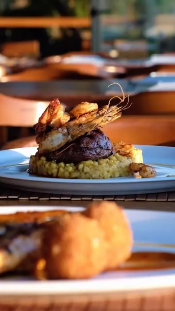 King prawns over steak with risotto at golden hour